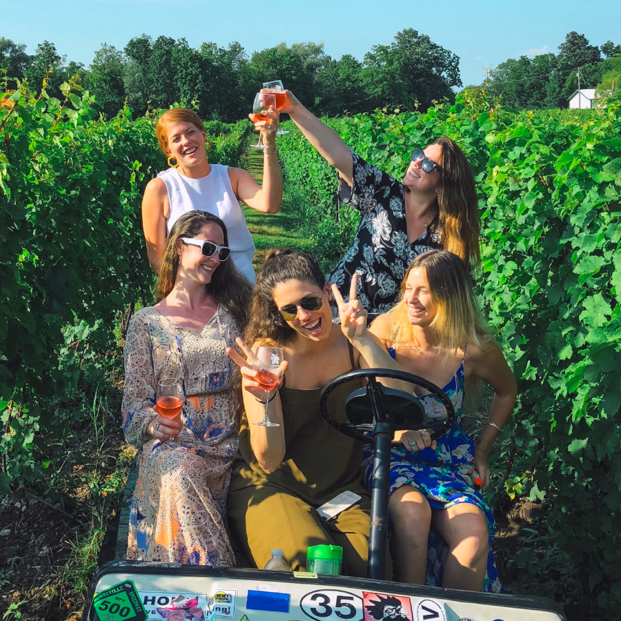 girls in the vineyard with wine glasses
